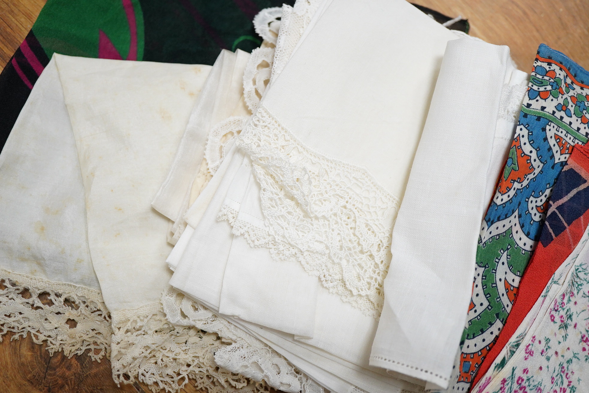 A collection of hankies, including a silk circa 1985 Christian Dior silk advertising ‘Poison’ hanky, Honiton bobbin lace and four other bobbin lace hankies, mixed machine lace hankies and 1930’s printed hankies. 33cm squ